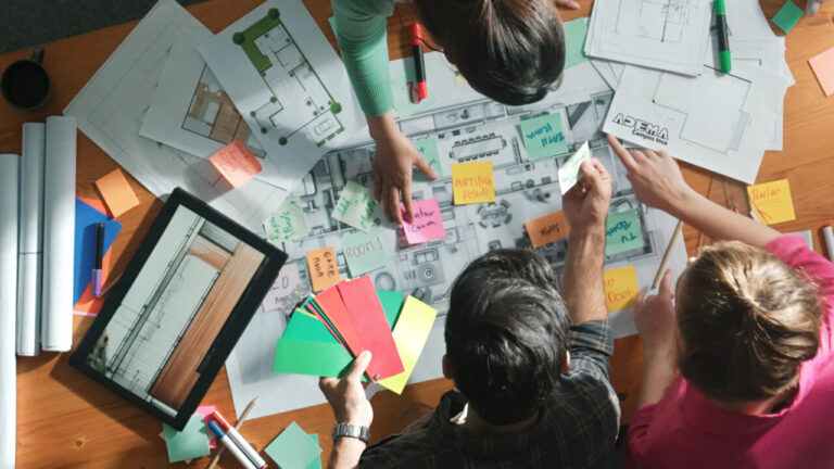 Grupo de personas trabajando en diseño de interiores con planos y materiales
