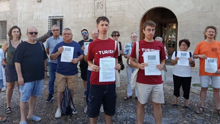 Grupo de personas sosteniendo carteles en protesta contra el turismo