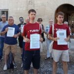 Grupo de personas sosteniendo carteles en protesta contra el turismo