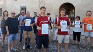 Grupo de personas sosteniendo carteles en protesta contra el turismo