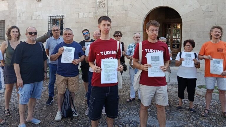 Grupo de personas sosteniendo carteles en protesta contra el turismo
