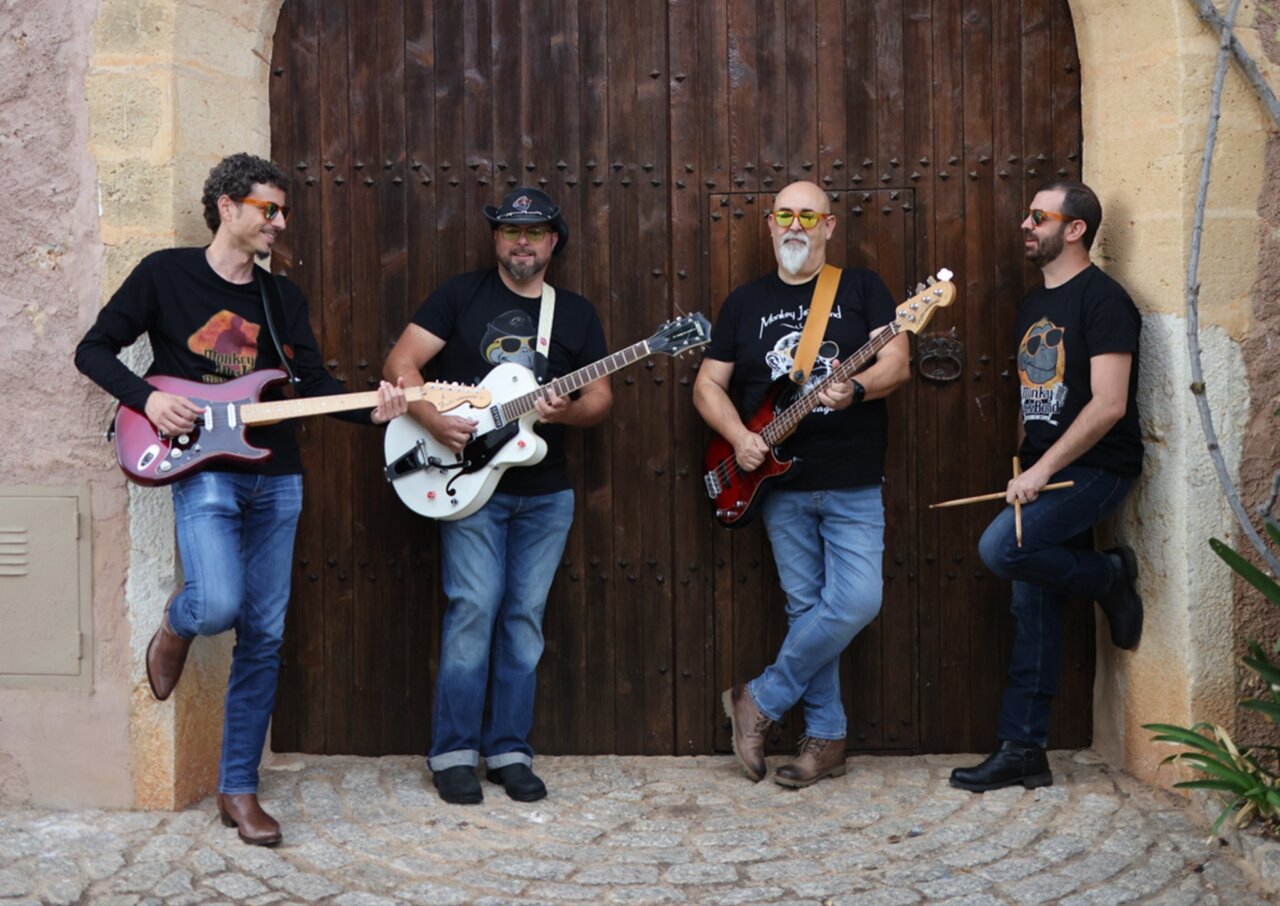 Miembros de la banda Monkey Jack Band posando con guitarras