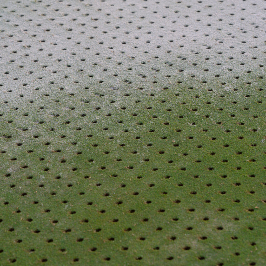 Superficie de un green de golf con agujeros de aireación