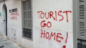 Pintadas en la pared que dicen Tourist Go Home en rojo