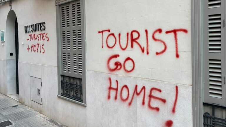 Pintadas en la pared que dicen Tourist Go Home en rojo