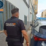 Agente de la Policía Nacional junto a un coche patrulla en Pere Garau