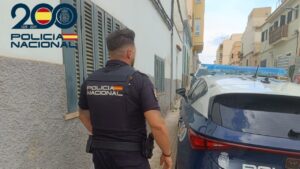 Agente de la Policía Nacional junto a un coche patrulla en Pere Garau