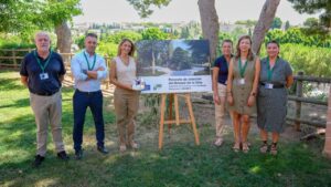 Grupo de personas junto a un cartel del Bosque de la Vida en Palma