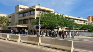 Edificio de administraci&oacute;n con personas haciendo fila para regularizaci&oacute;n de extranjeros