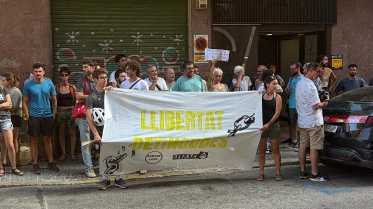 Concentración de personas en los juzgados de Palma con una pancarta de apoyo.