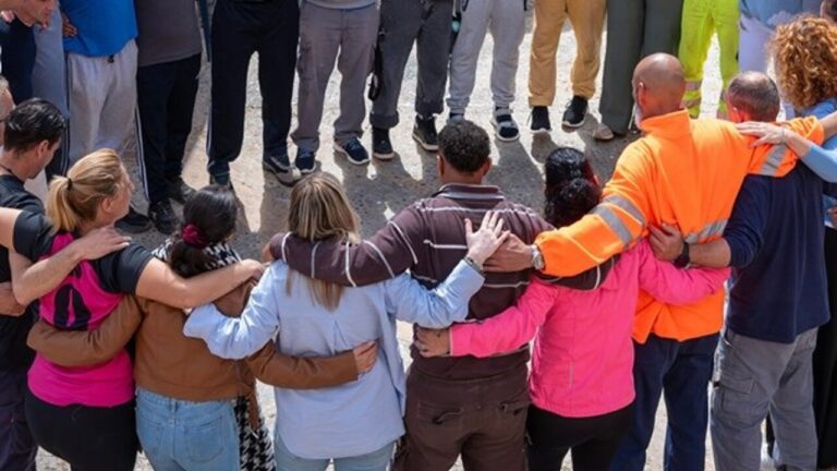 Grupo de personas abrazadas en un círculo durante una actividad de apoyo