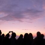 Personas observando un atardecer mientras esperan un eclipse solar