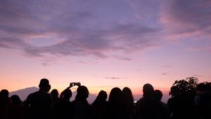 Personas observando un atardecer mientras esperan un eclipse solar