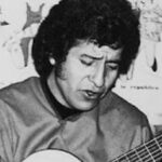 Víctor Jara tocando la guitarra en una actuación musical