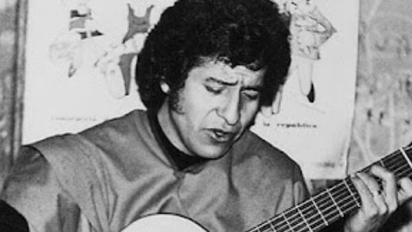 Víctor Jara tocando la guitarra en una actuación musical