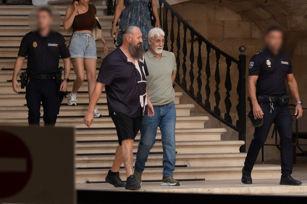 Dos hombres caminando por escaleras con polic&iacute;as en el fondo