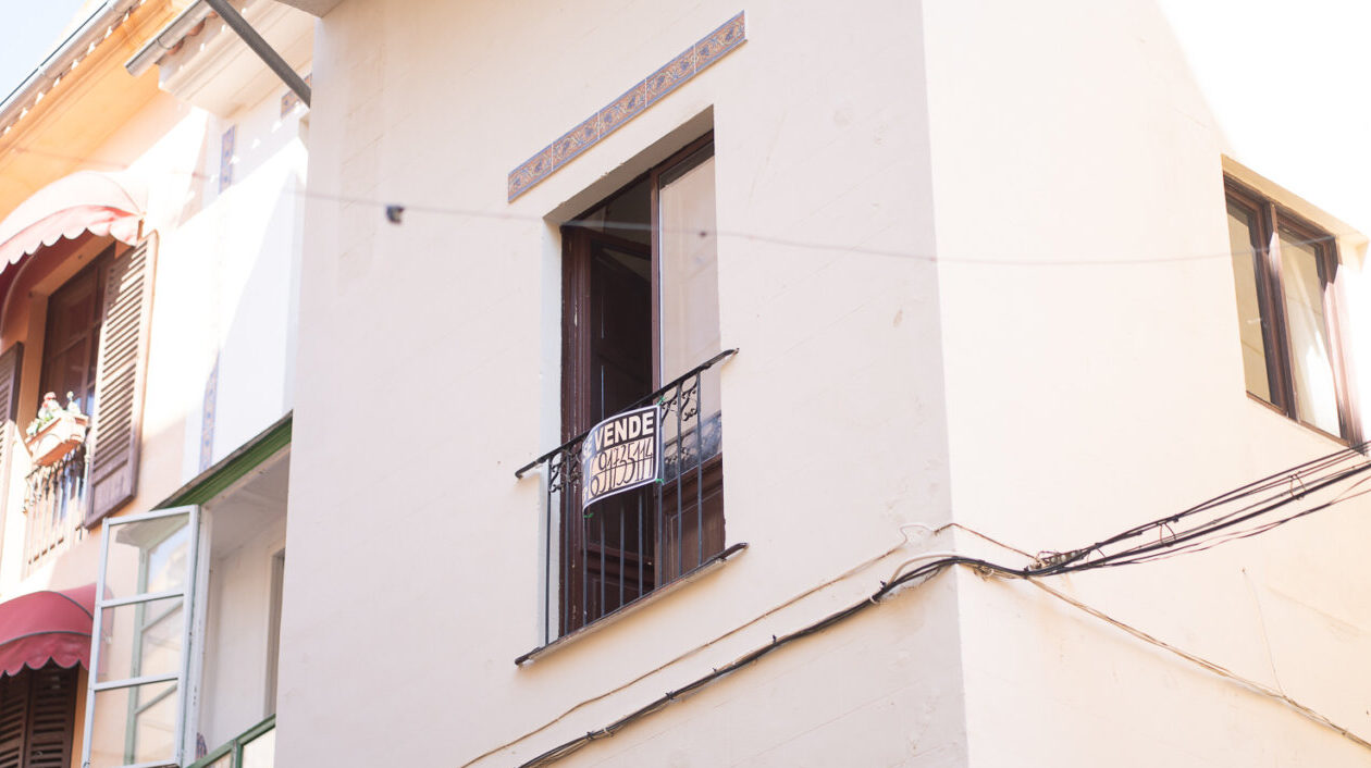 Vista de un balc&oacute;n con un cartel de venta en una casa