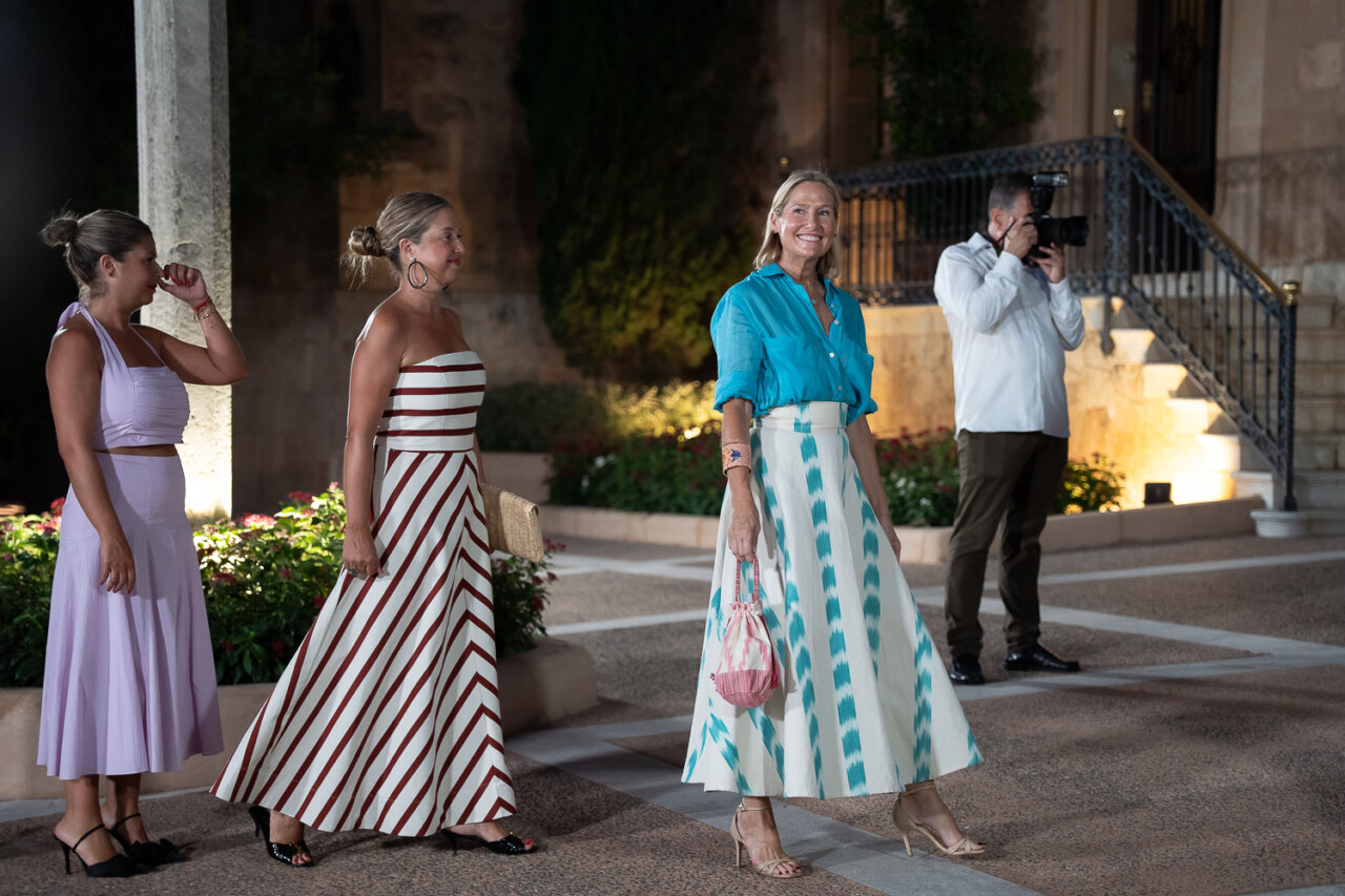 Tres mujeres caminando en un evento social elegante en Mallorca.