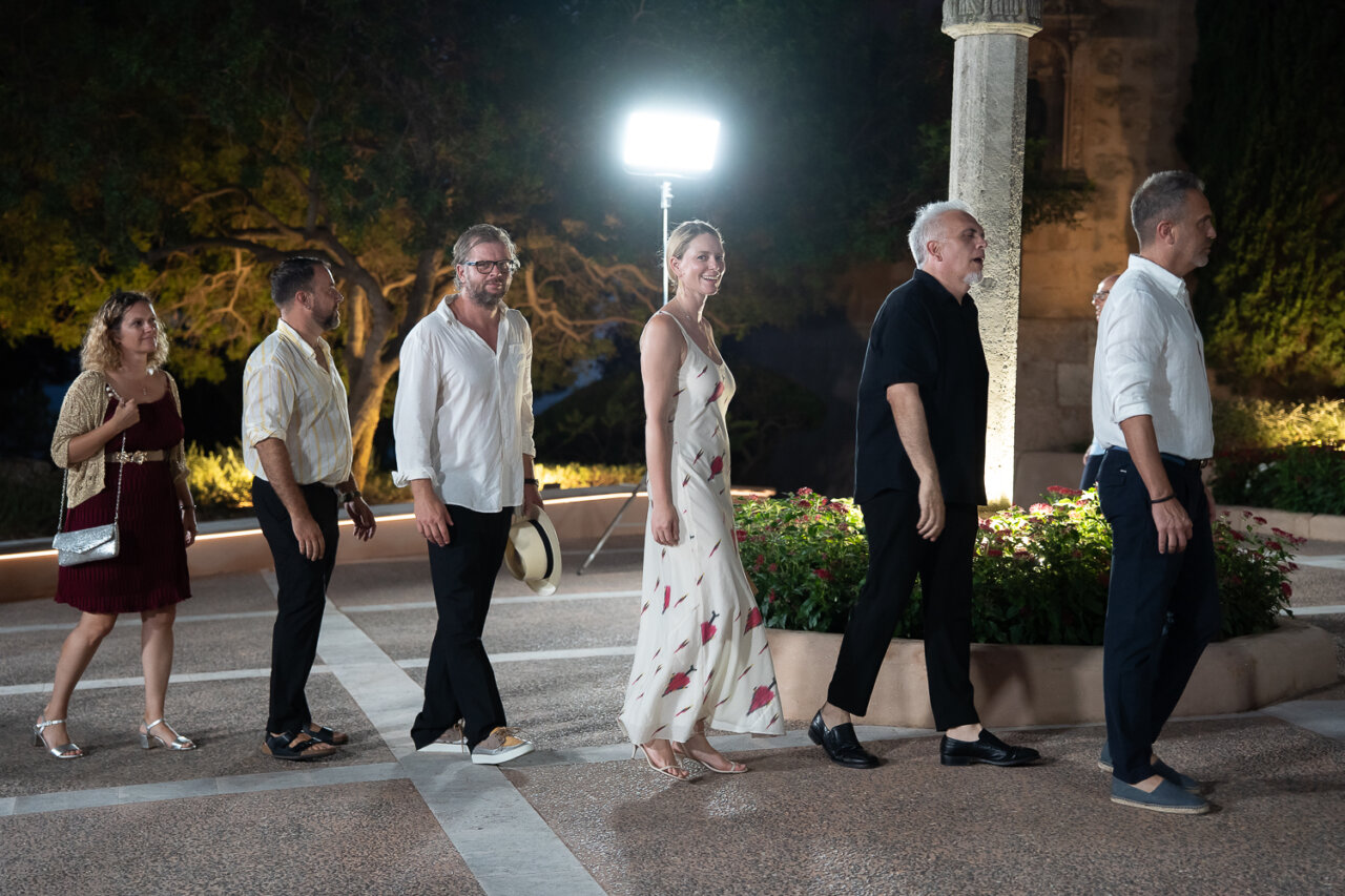 Grupo de personas caminando en un evento nocturno al aire libre