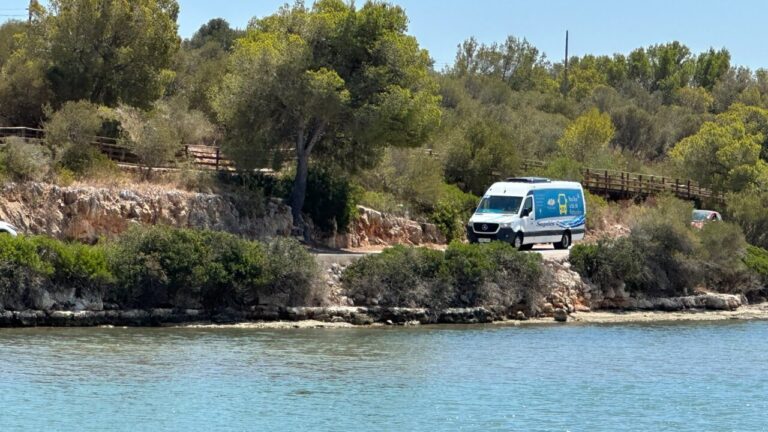 Bus urbano de Portocolom circulando por un camino junto al mar