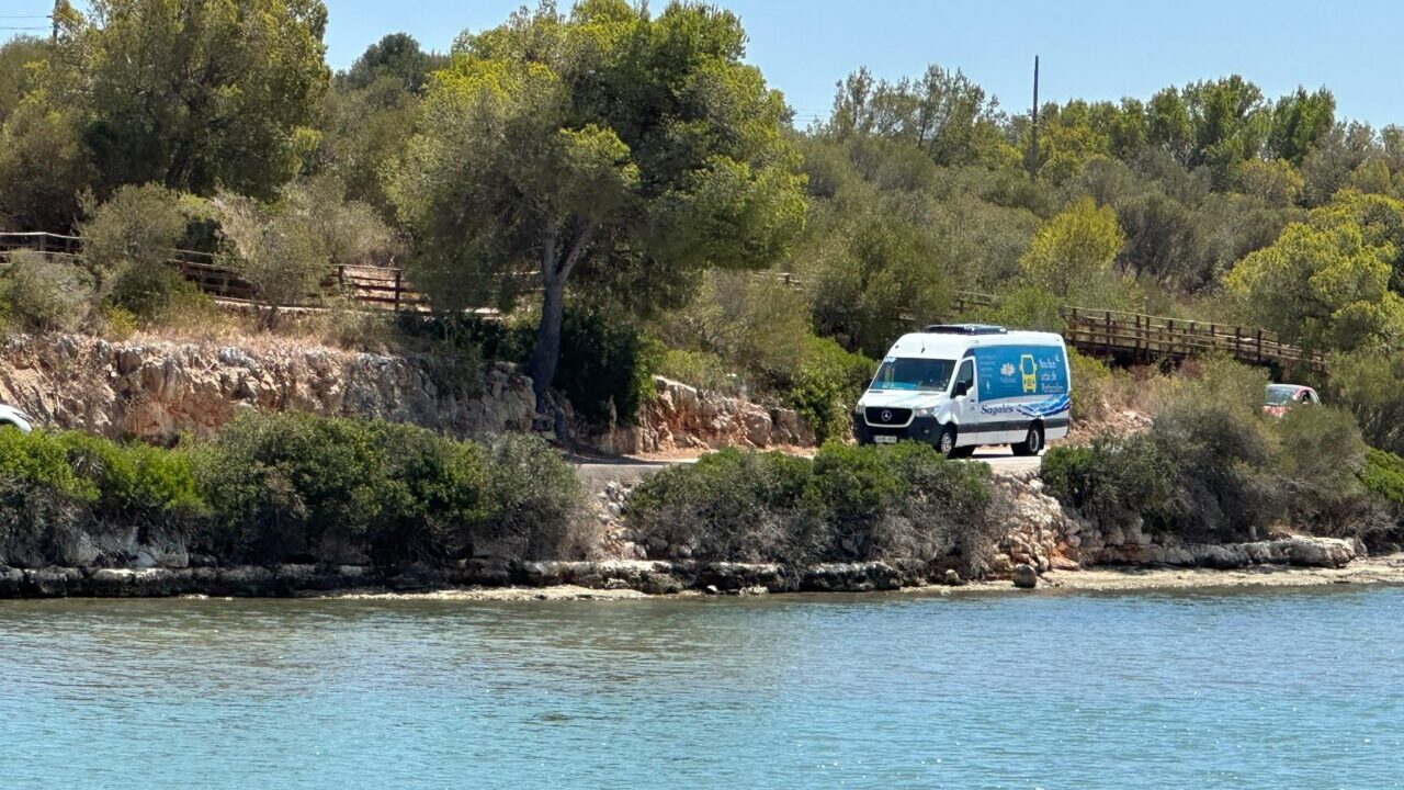 Bus urbano de Portocolom circulando por un camino junto al mar