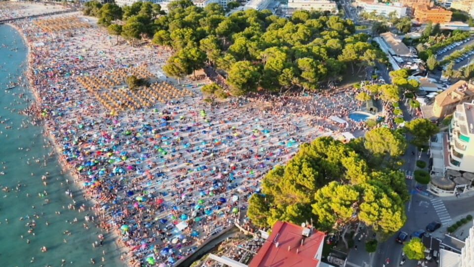 Vista aérea de la playa de Santa Ponça con muchas personas y sombrillas