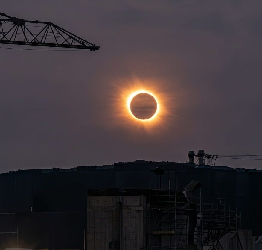 Eclipse total de sol visto desde Mallorca con edificios y gr&uacute;as