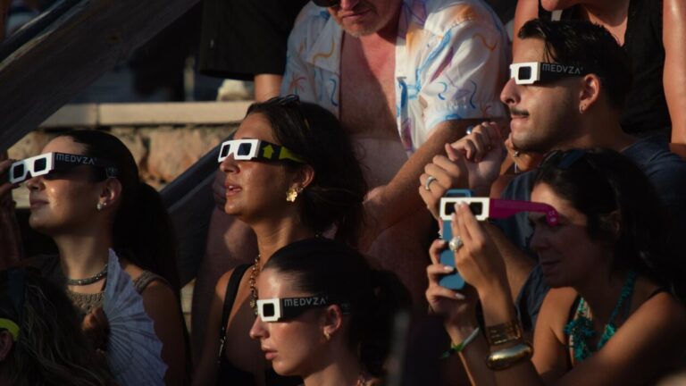 Grupo de personas observando un eclipse solar con gafas especiales