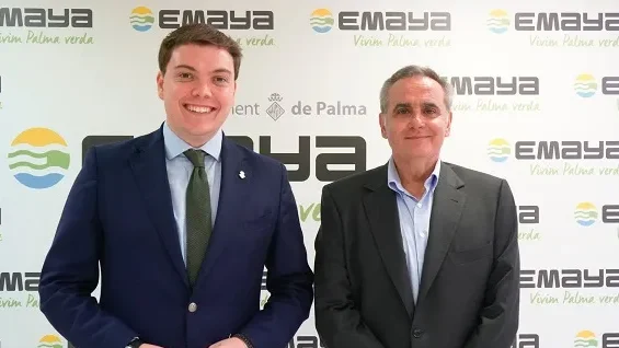 Dos hombres posando en la oficina de EMAYA con logo visible