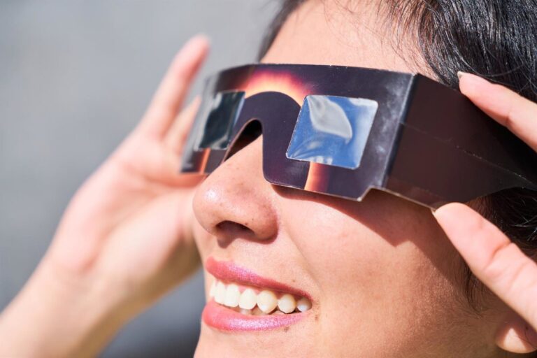 Persona usando gafas de eclipse solar con una sonrisa