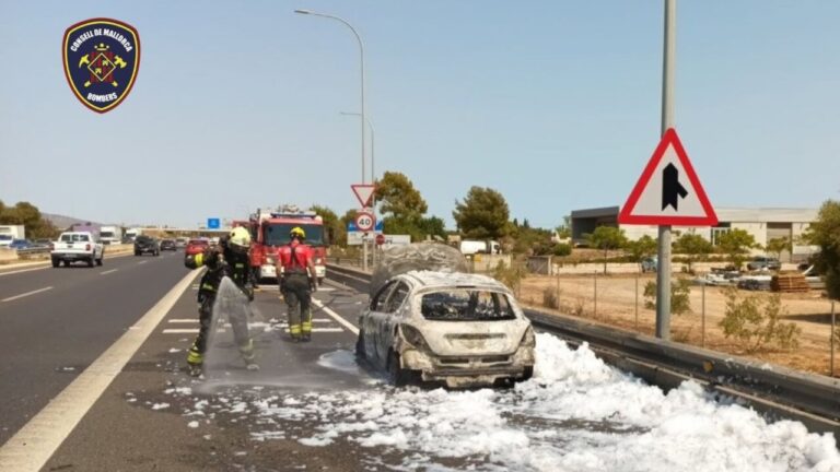 Bomberos apagando un coche en llamas en la autopista Ma-13