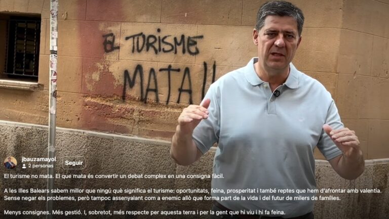 Jaume Bauz&aacute; hablando frente a pintadas contra el turismo en la Conselleria.