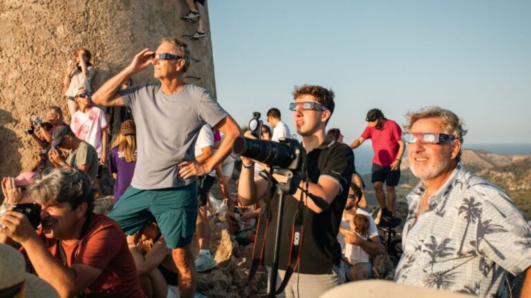 Varias personas observan un eclipse solar total en el Cabo de Formentor
