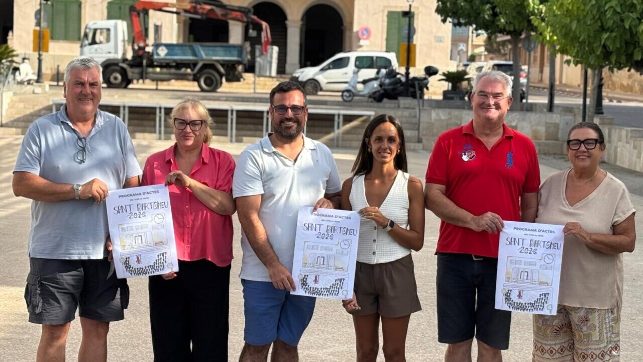 Grupo de personas sosteniendo carteles del programa de Sant Bertomeu 2023