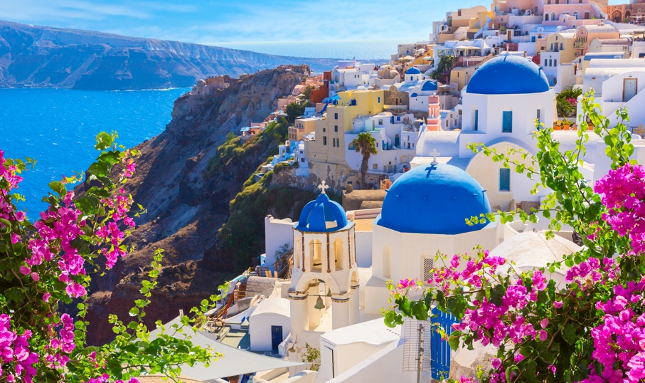 Vista de casas blancas y azules en Santorini con flores