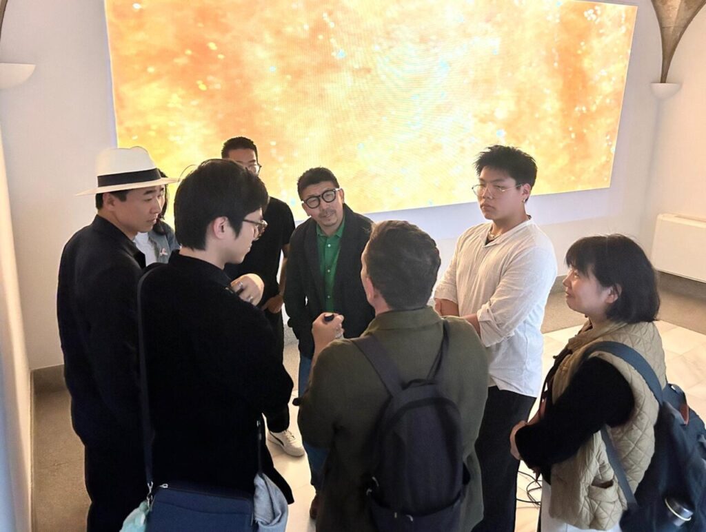 Yu Depeng interactuando con visitantes en una exposici&oacute;n de arte contempor&aacute;neo.